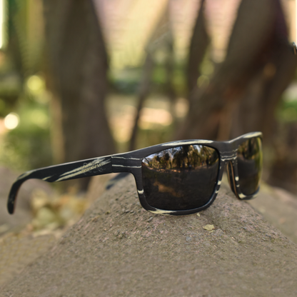 Lentes solares de madera chapada en ébano color negro con vetas en color blanco con lentes polarizados en color humo. Actitud Salvaje.  Despiertas pensando en nuevos caminos y nuevos retos, te gusta la naturaleza en su ámbito salvaje. Lentes Solares de Madera Viajero Cebra.